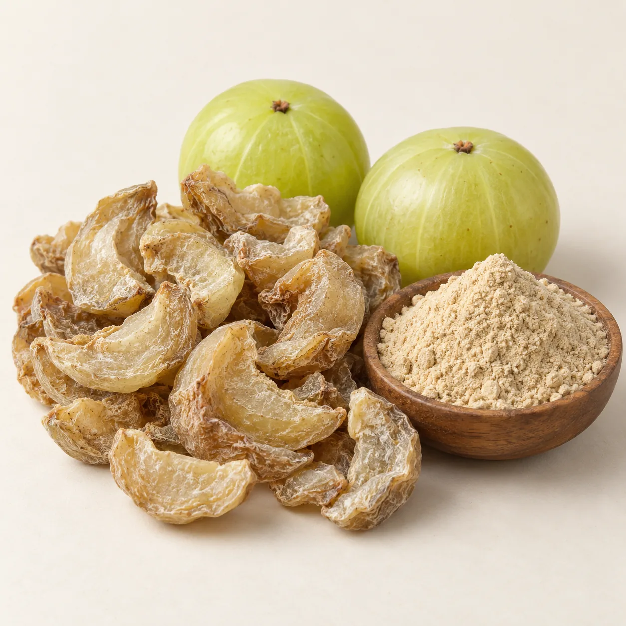 Illustrative dried Amla fruit pieces and powder beside fresh fruit
